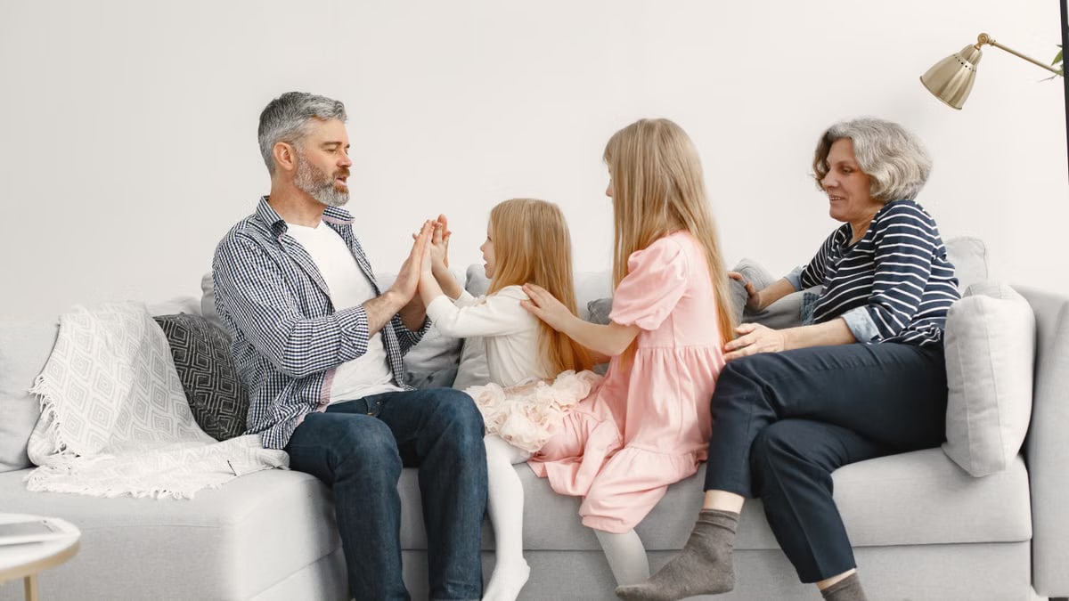 A joyful family spends quality time together, playing and bonding on a cozy sofa.